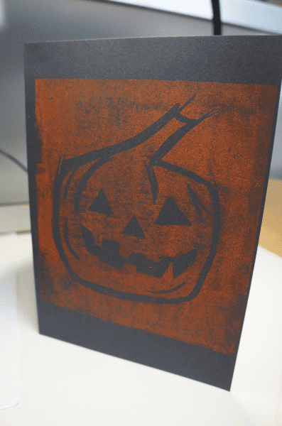 Black card with orange printed halloween pumpkin