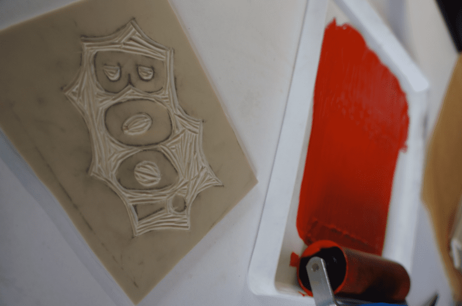 Orange ink on ink tray with roller, ready to roll onto carved design