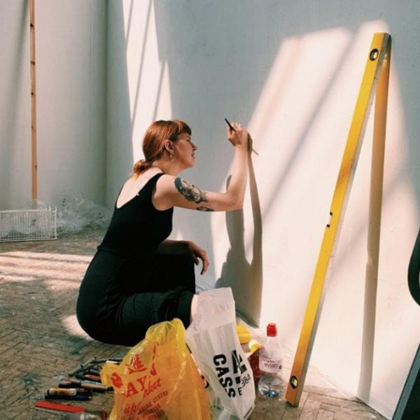 Jasmine Turton, lino print artist, drawing onto a wall
