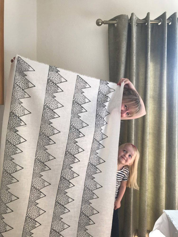 Hayley Anderson with Molly Hayley Anderson and young daughter Molly peaking out from behind linoprinted fabric