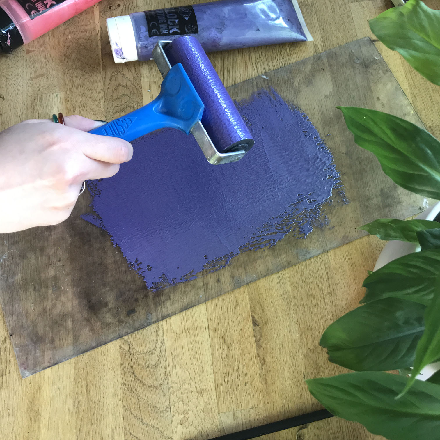 baren being used to transfer printed monstera leaf onto paper