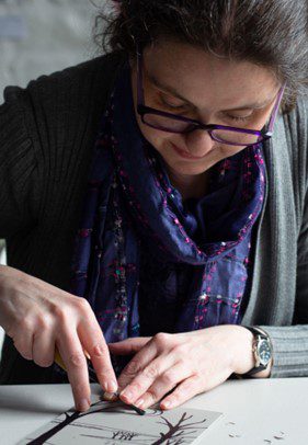 Photo of linoprint artist Vicki Jordan carving a linoprint