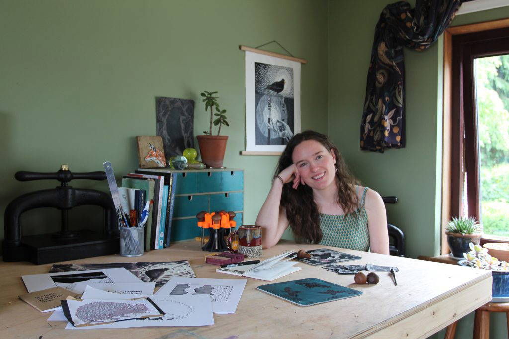 Judith Wild carving a lino block at her studio desk in Renfrewshire.